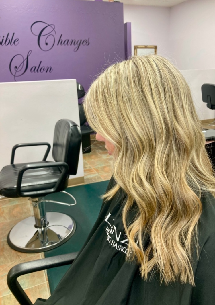 A woman is sitting in a chair in a salon.