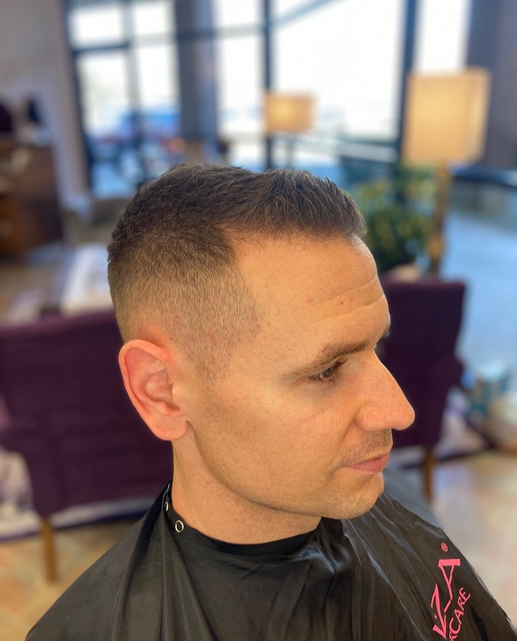 A man is getting his hair cut in a salon.