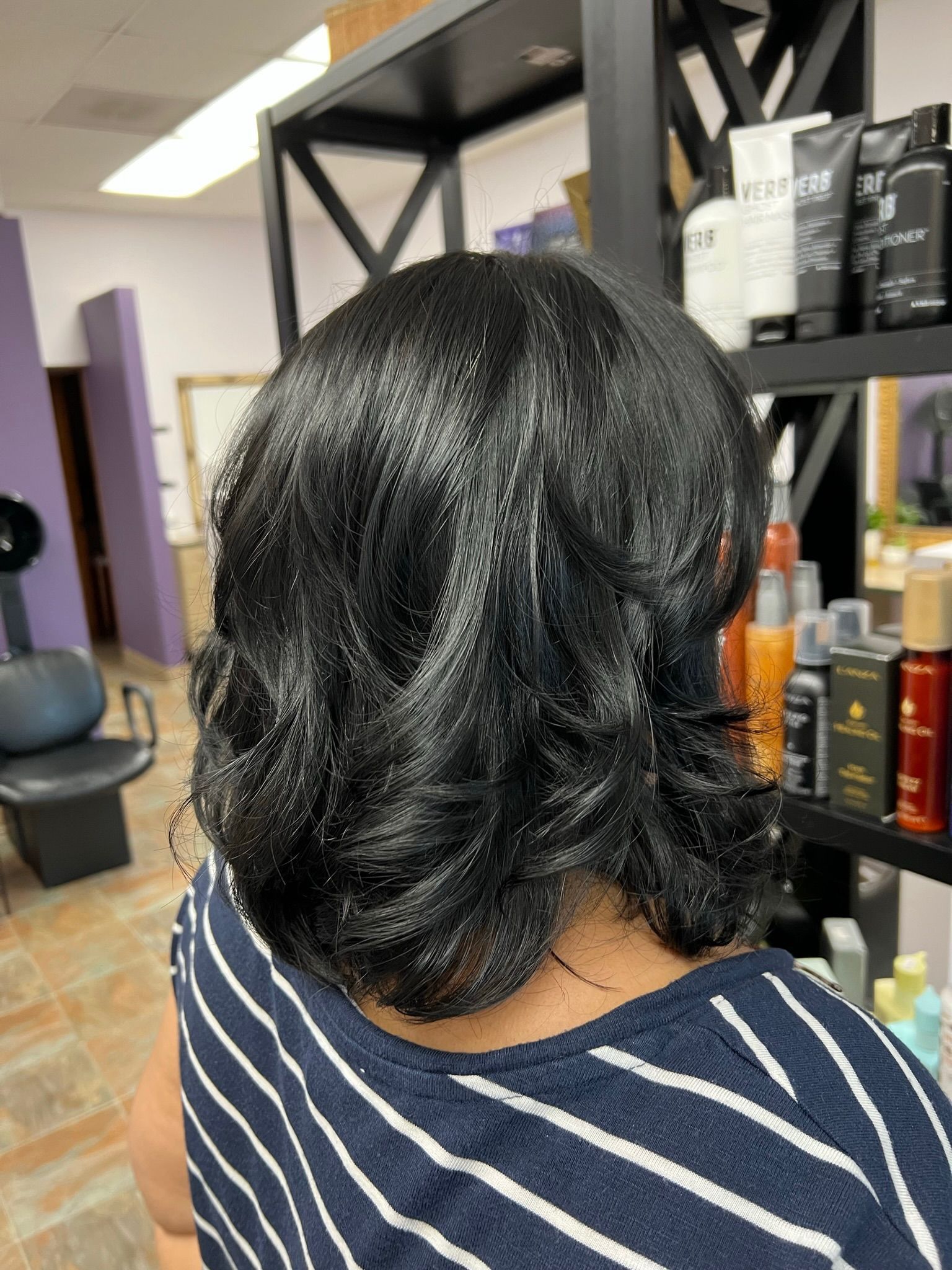 The back of a woman 's head is shown in a hair salon.