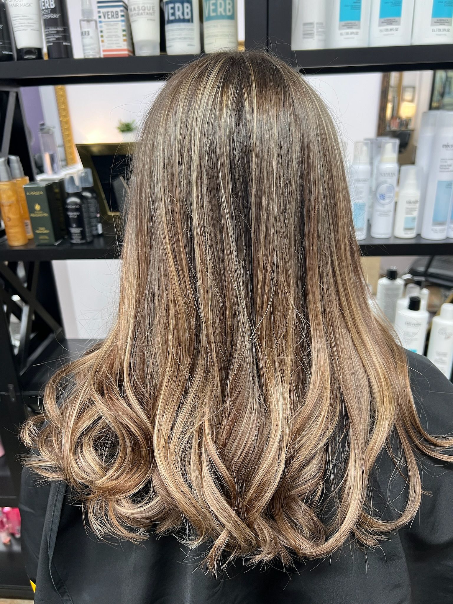 A woman is sitting in a chair with her hair covered in glitter.