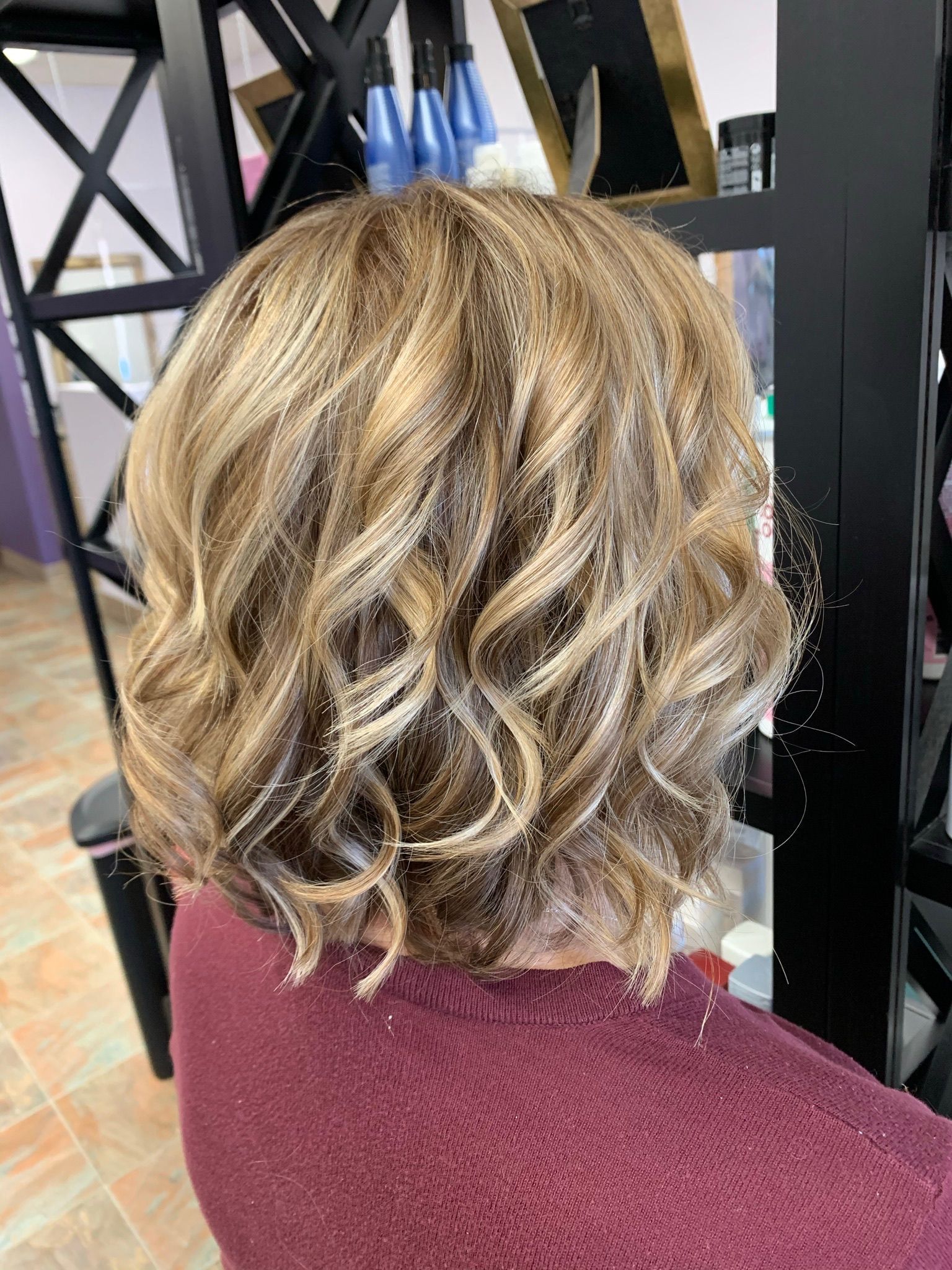 A woman is sitting in a chair with her hair in a bun.