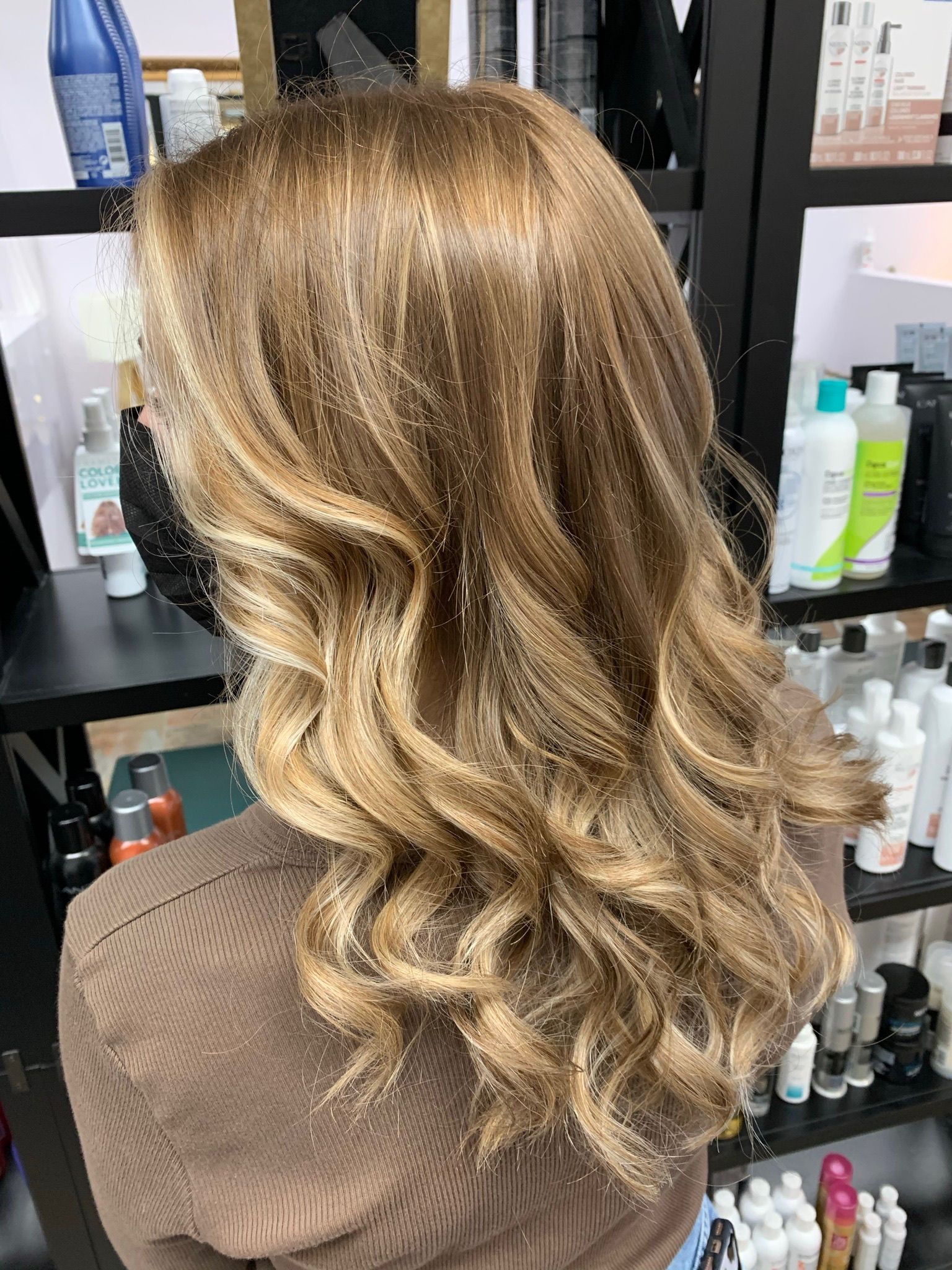 A woman with long blonde hair is sitting in a salon.