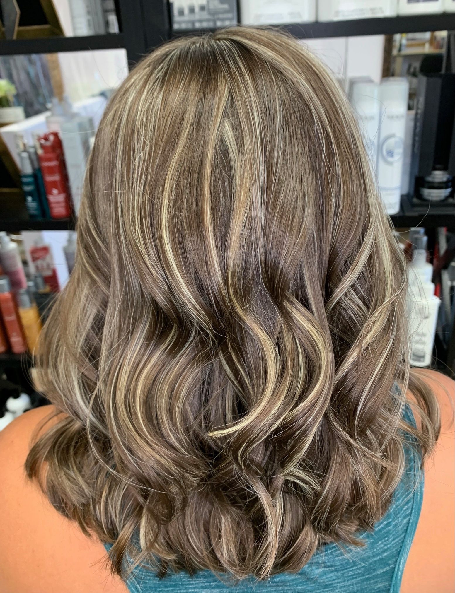The back of a woman's hair is shown in a salon.