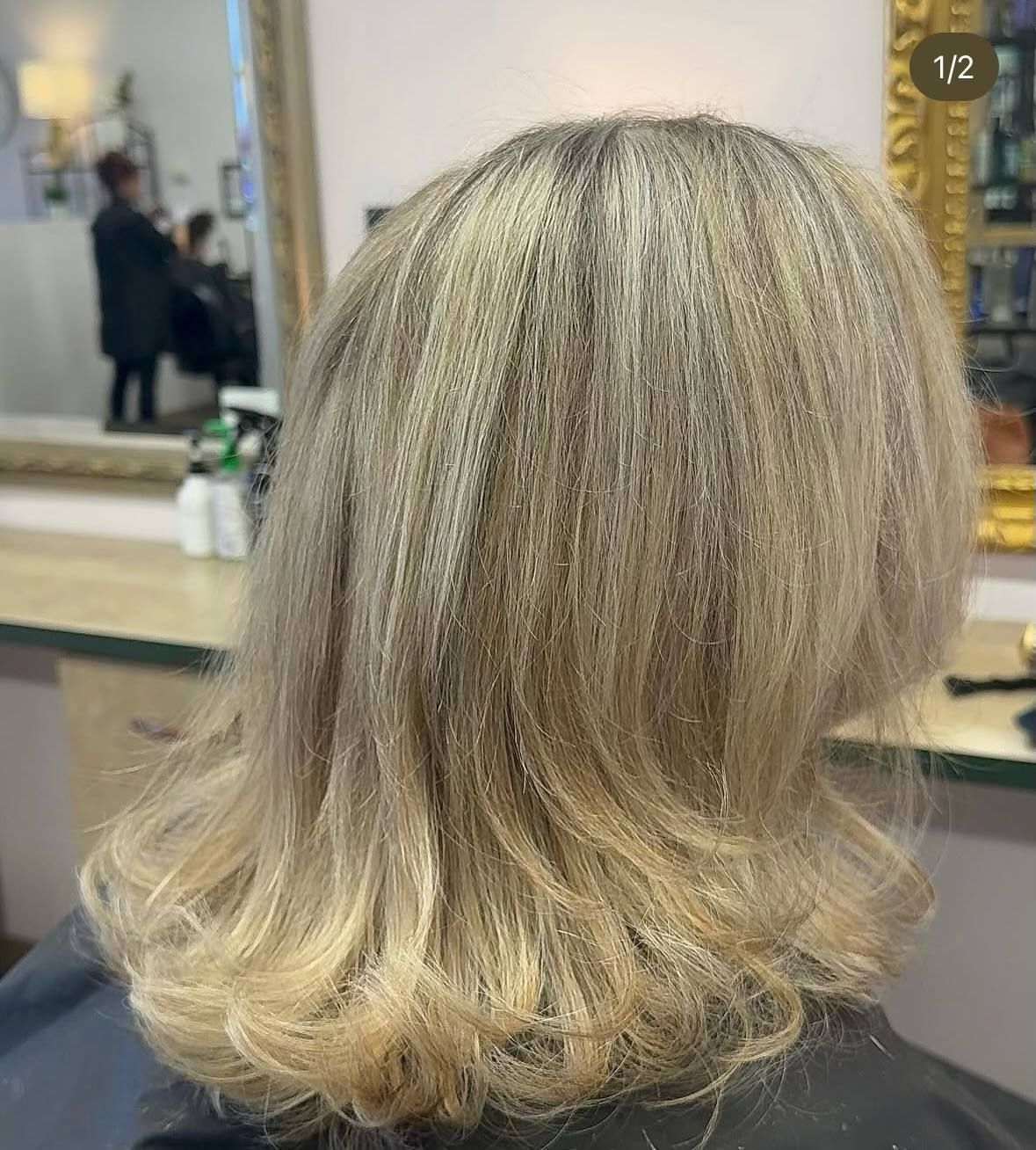 A woman is getting her hair cut in a salon.