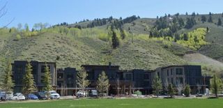 A group of buildings are sitting on top of a grassy hill.