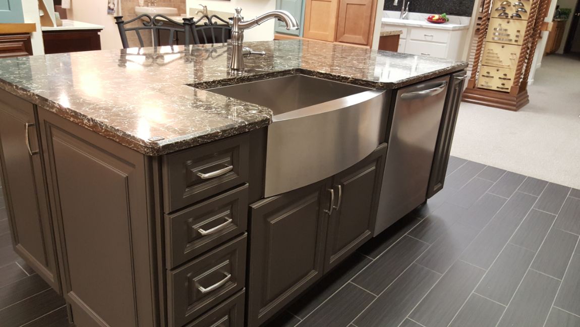 A kitchen island with a stainless steel sink and dishwasher