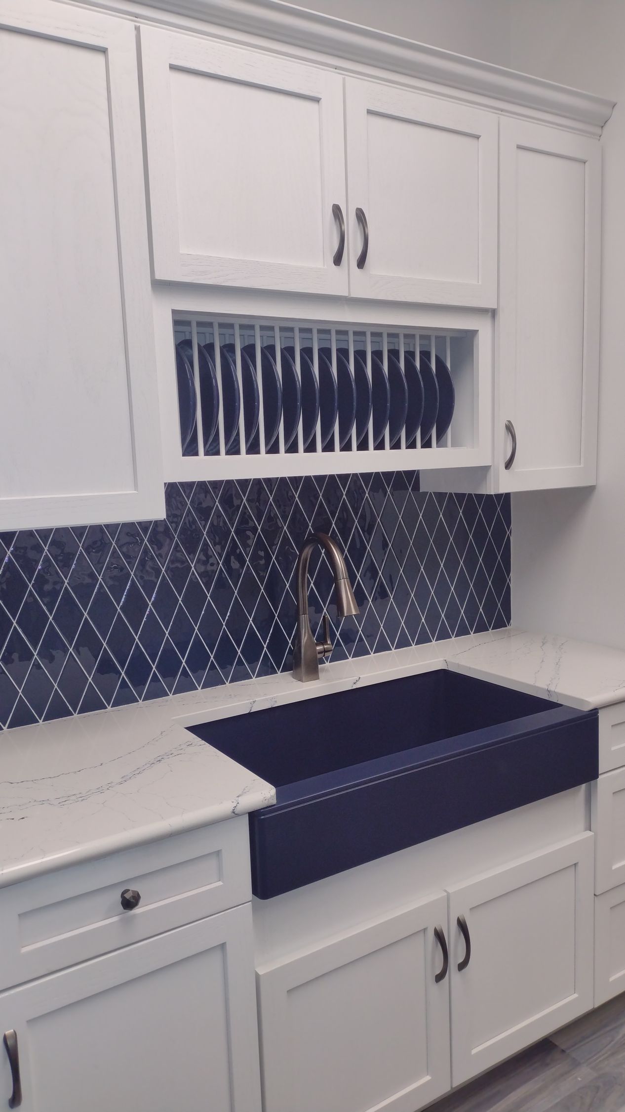 A kitchen with white cabinets and a blue sink