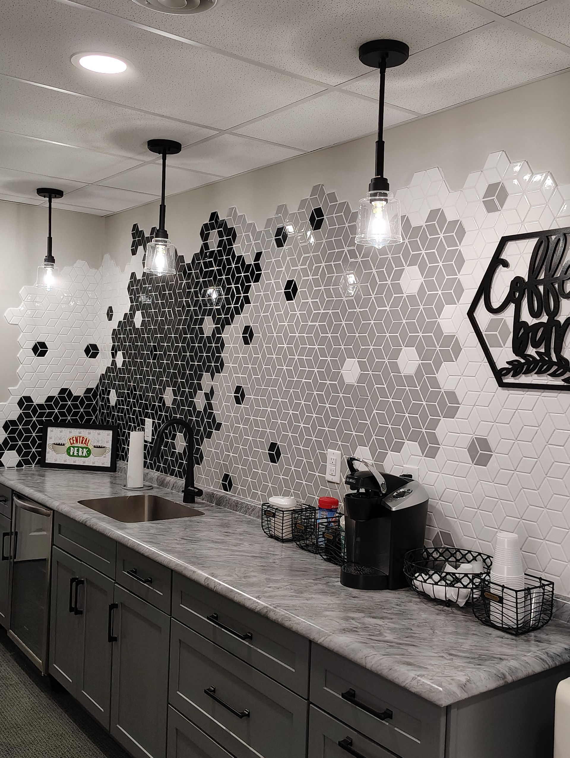 A kitchen with a sink, cabinets, and a map on the wall