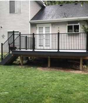 A house with a deck and stairs in front of it.