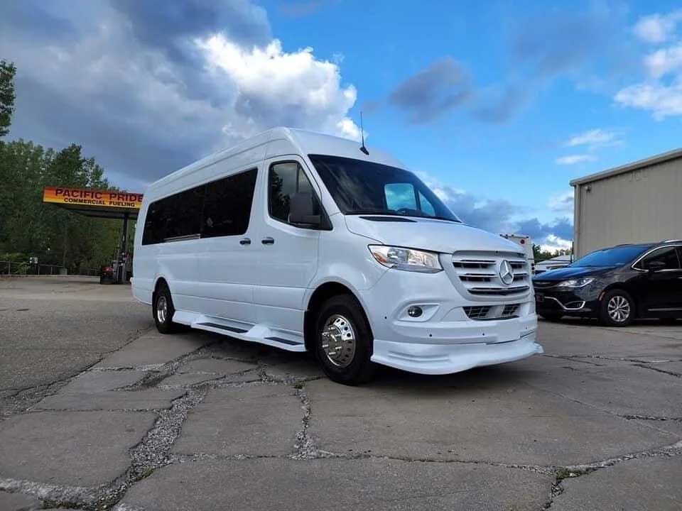White Mercedes-Benz Sprinter van parked on cracked pavement, under a cloudy sky.