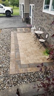 A patio with a table and chairs in front of a house.