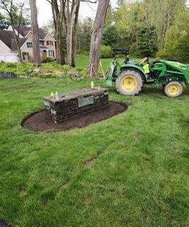 A green tractor is sitting on top of a lush green lawn.