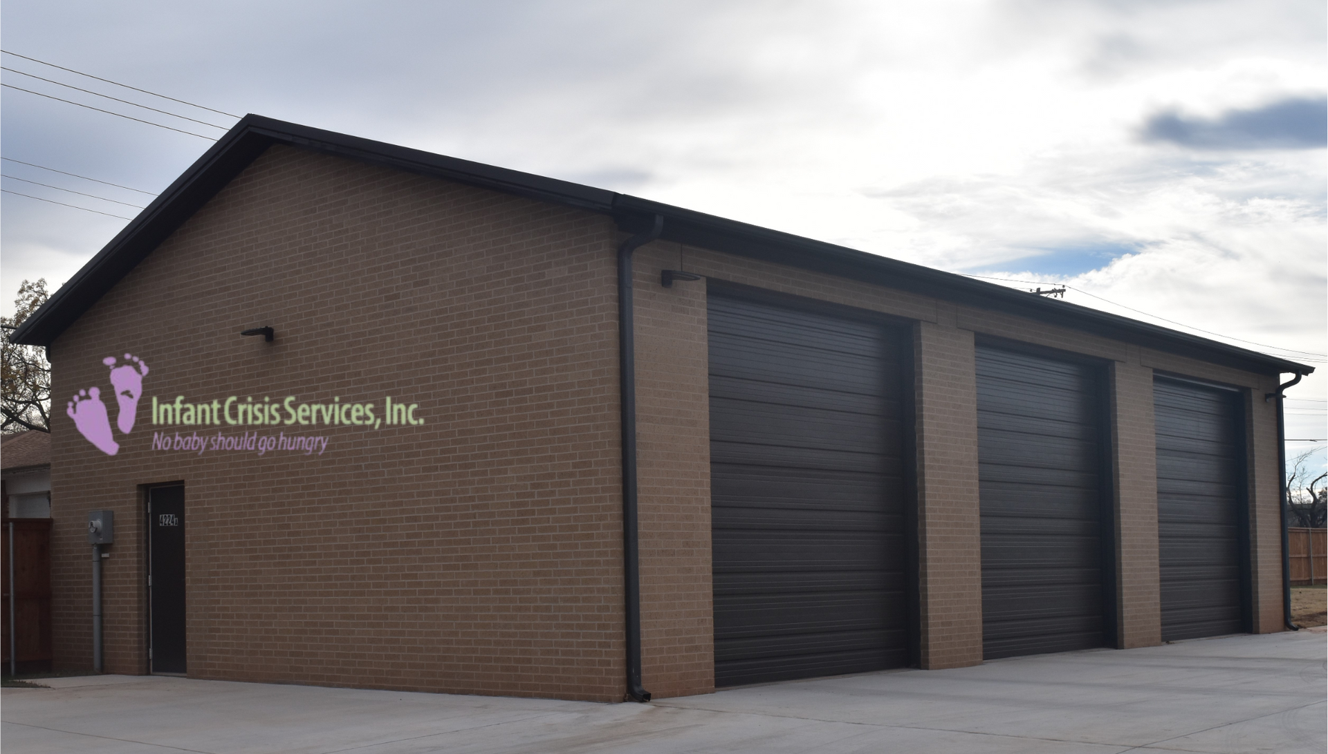Building with brick facade and three garage doors.
