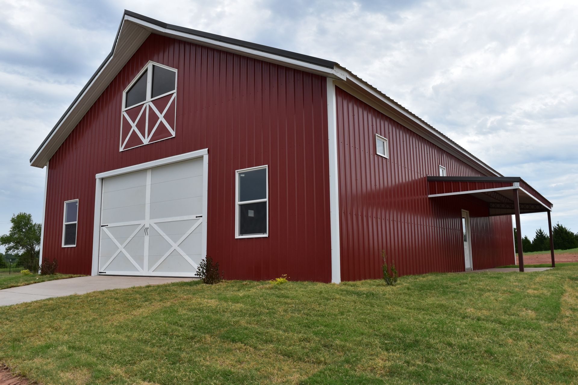 Red barn with white trim and door, set in grassy field.