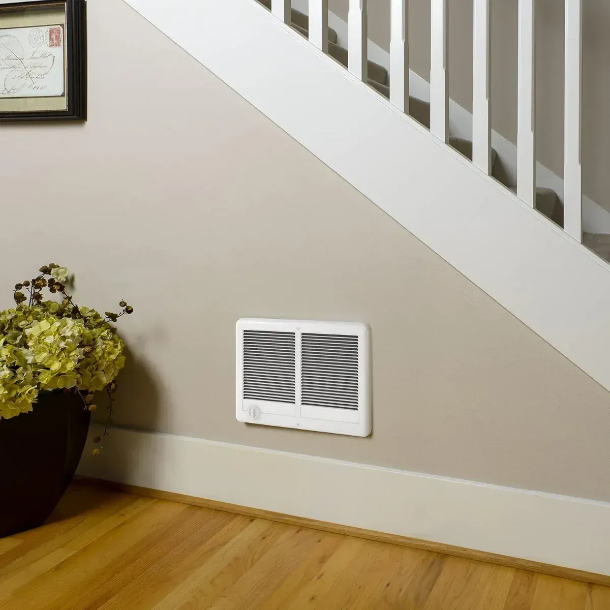 White wall heater on beige wall near stairs.
