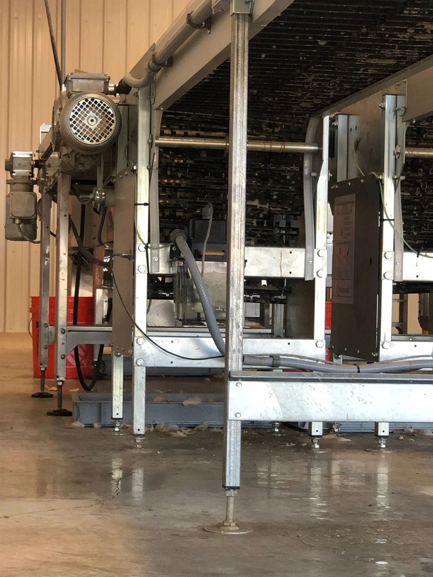 Industrial equipment in a warehouse setting, with metal framework, motors, and electrical components.