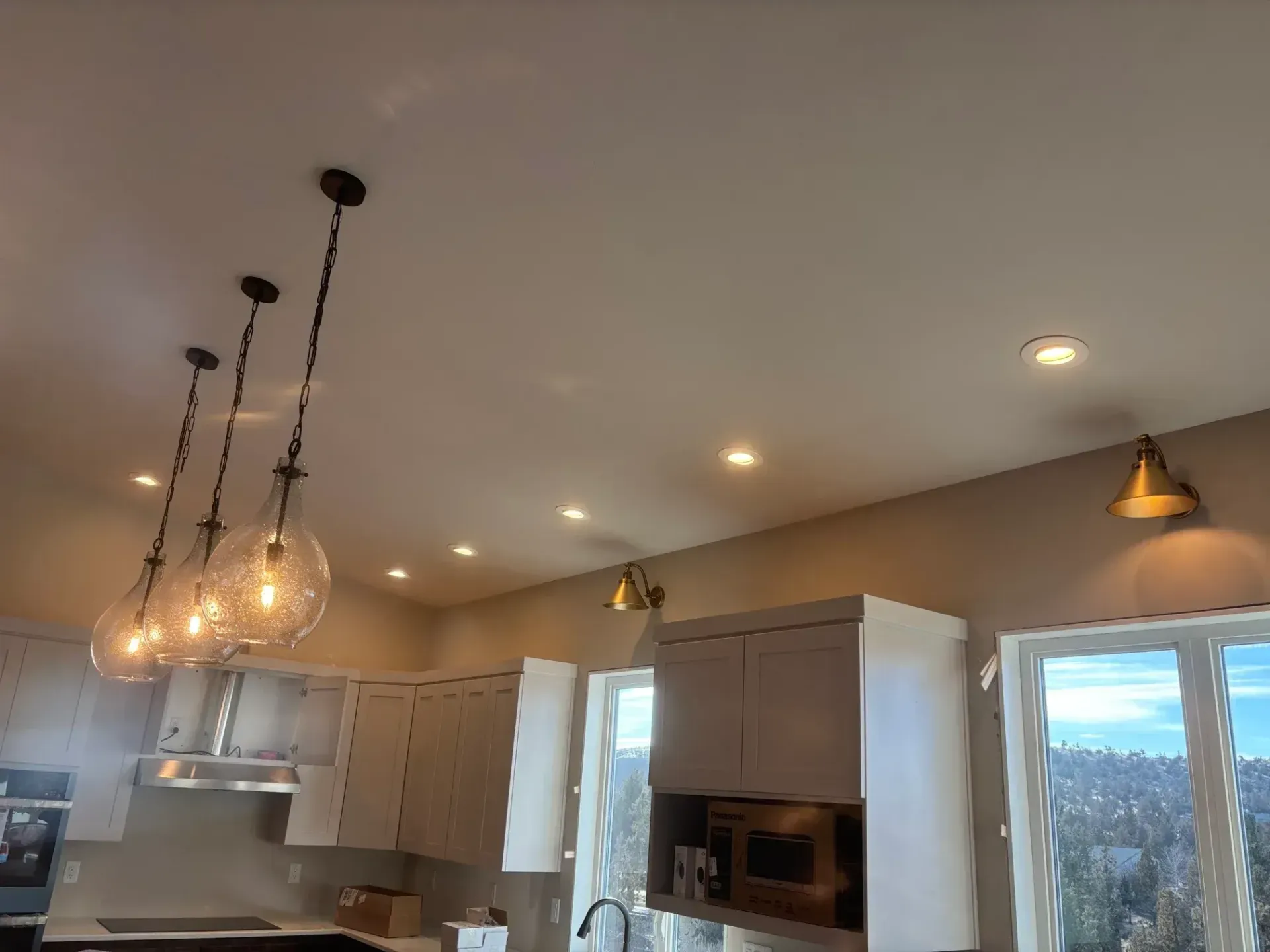 Kitchen with pendant lights, recessed lights, cabinets, and a window.