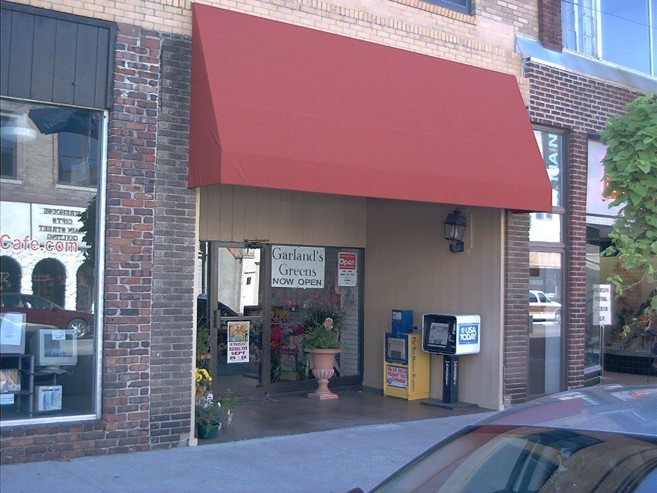 A brick building with a red awning over the entrance