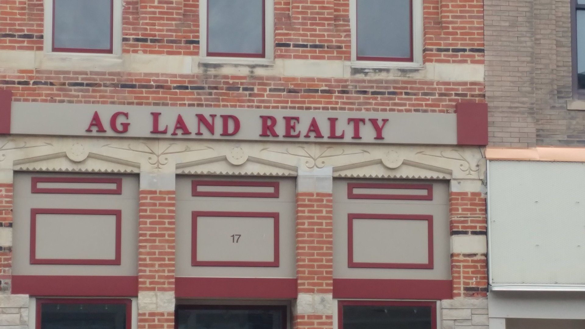 A brick building with a sign that says ag land realty