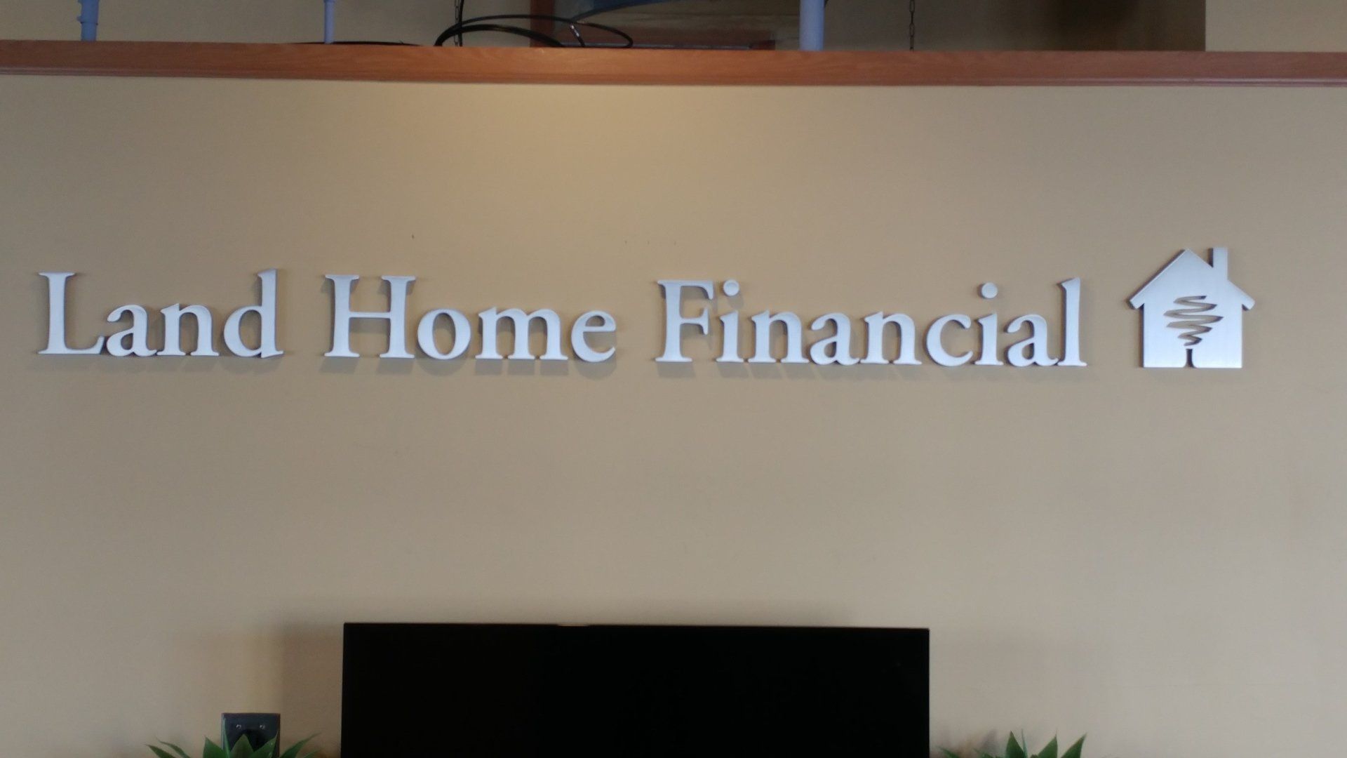 A sign on a wall that says land home financial