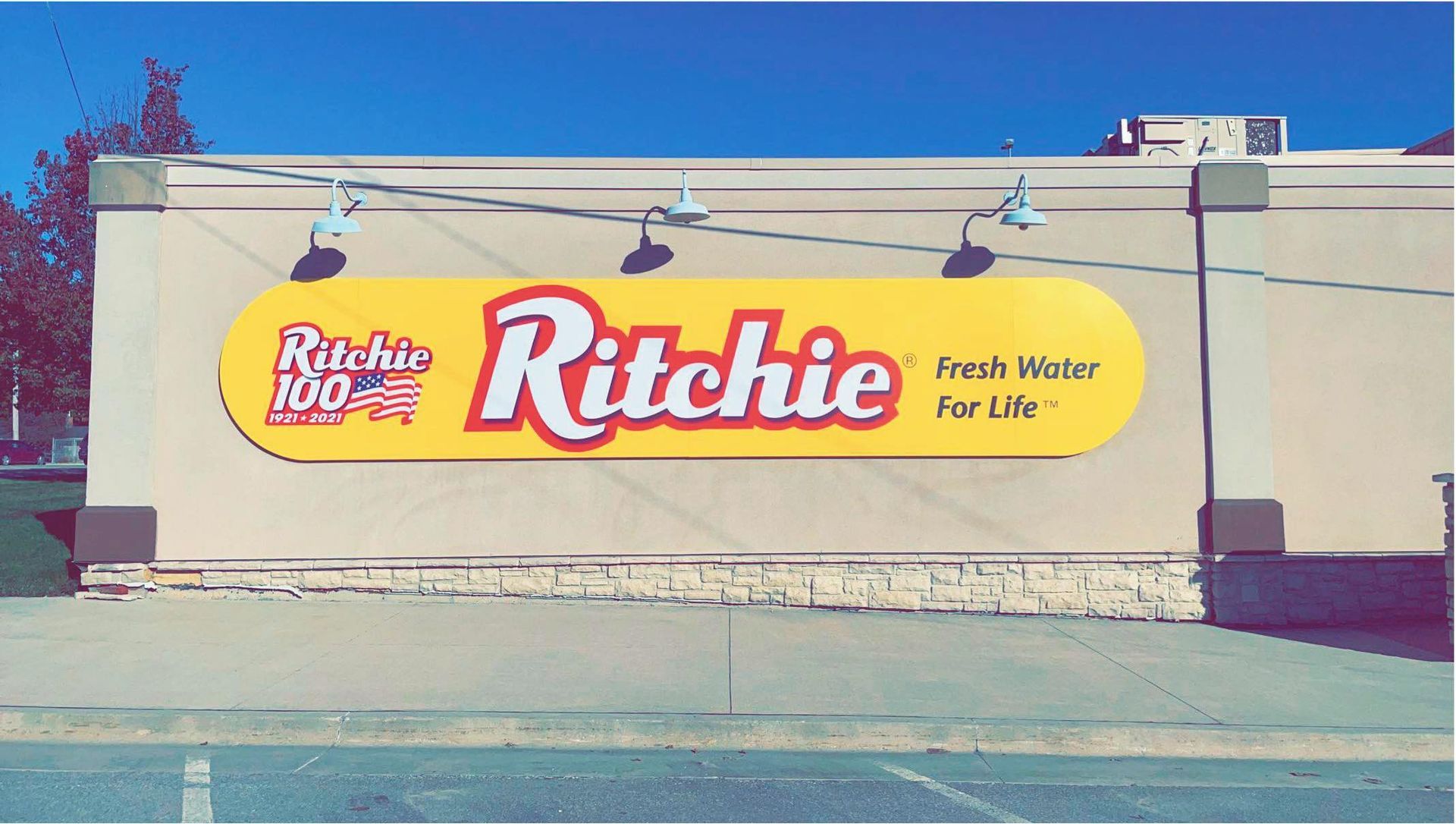 A sign for Ritchie 100 is on the side of a building