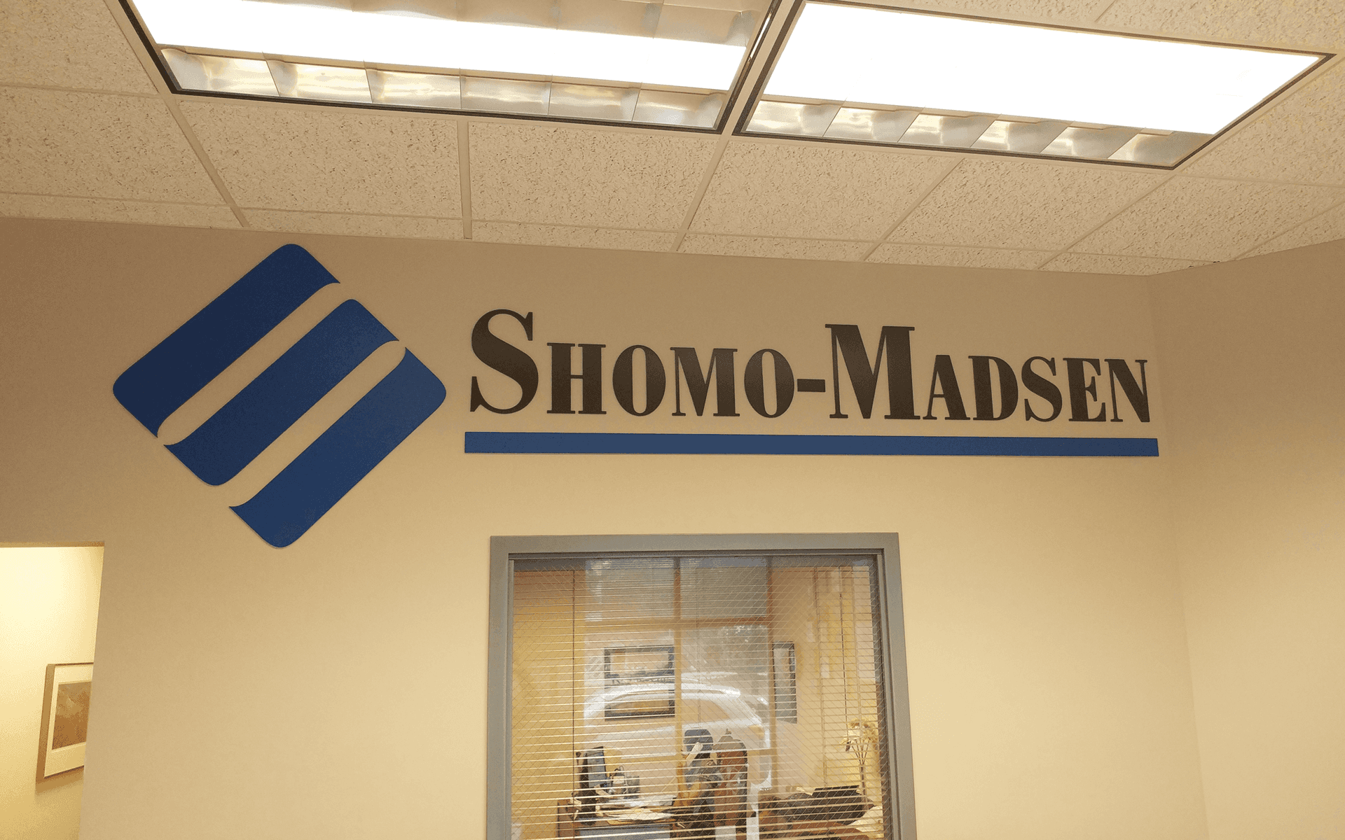 A sign on a wall that says shomo-madsen