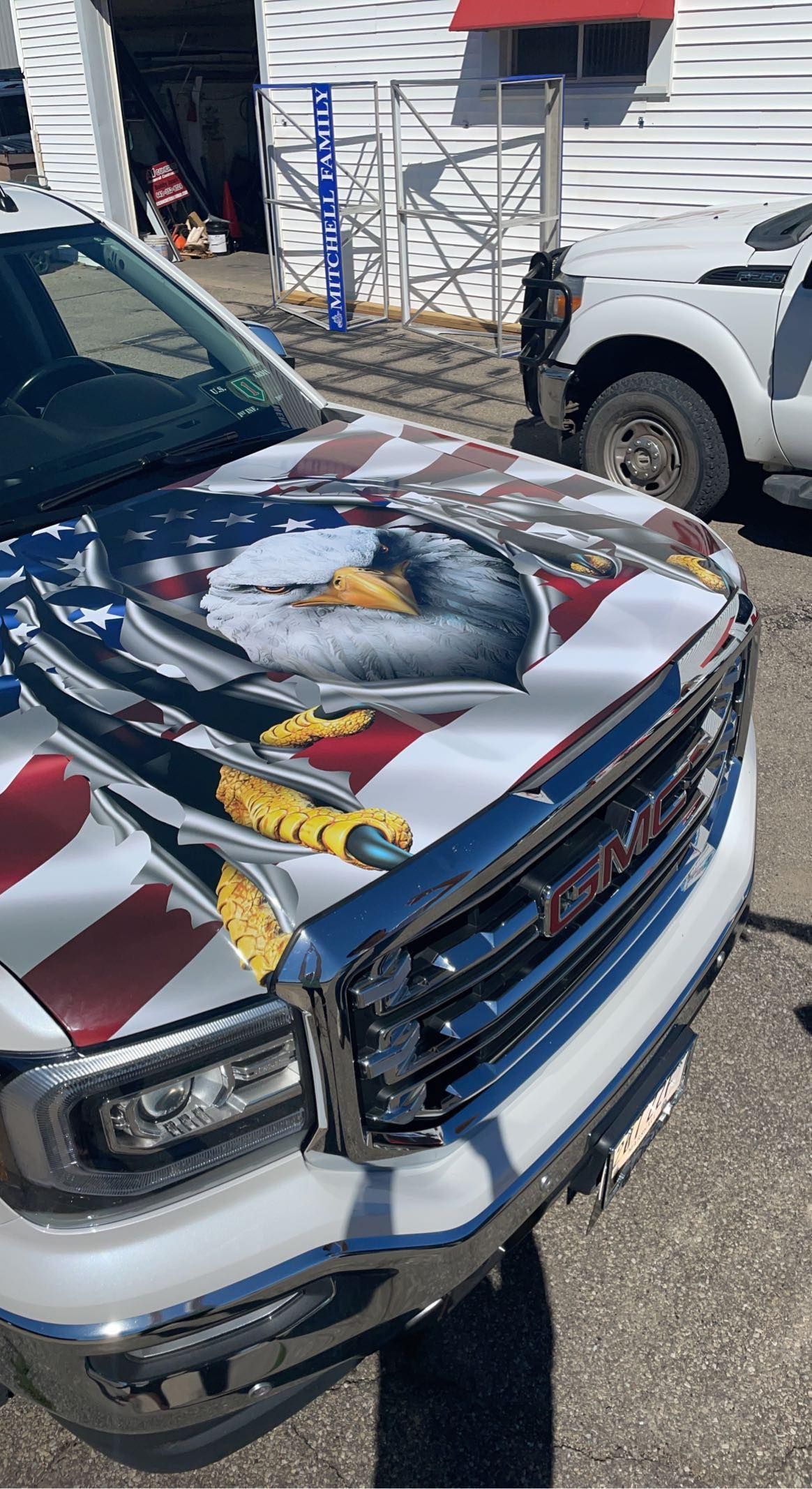A gmc truck with an american flag painted on the hood.