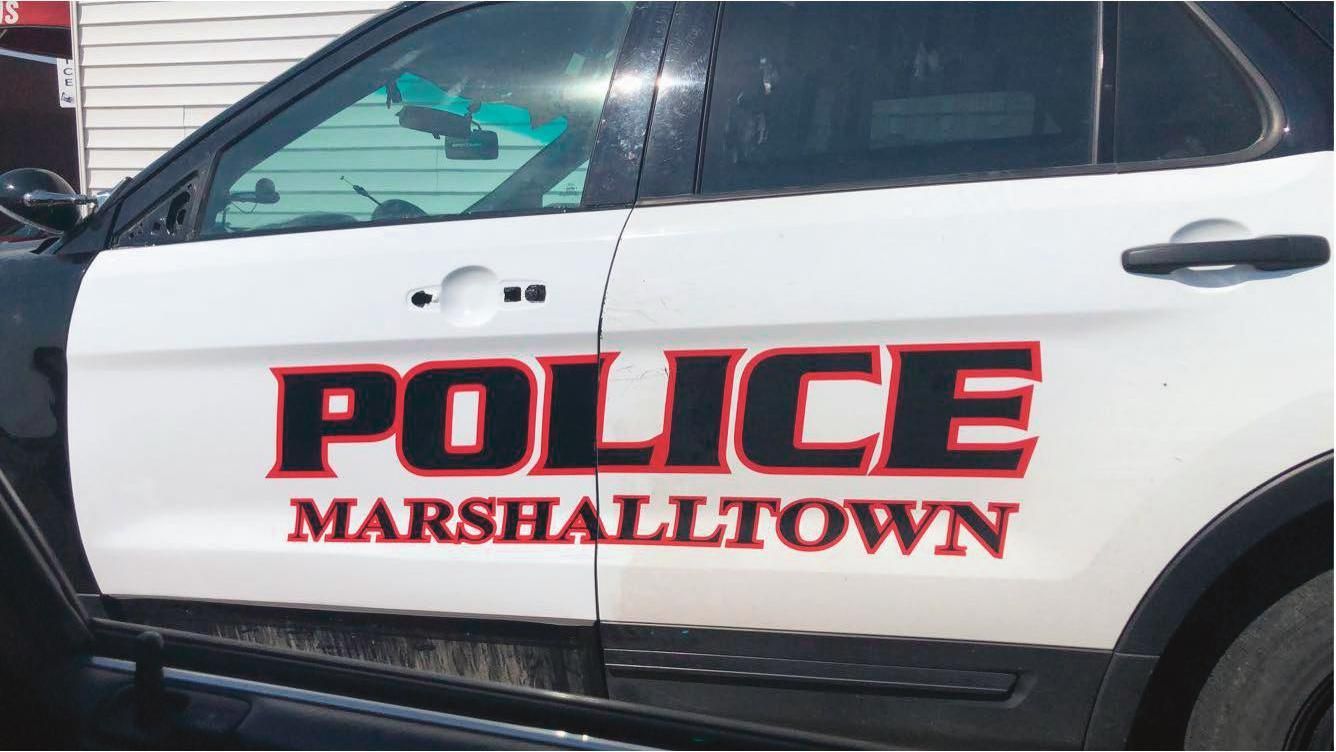 A white and black police car is parked in a parking lot.