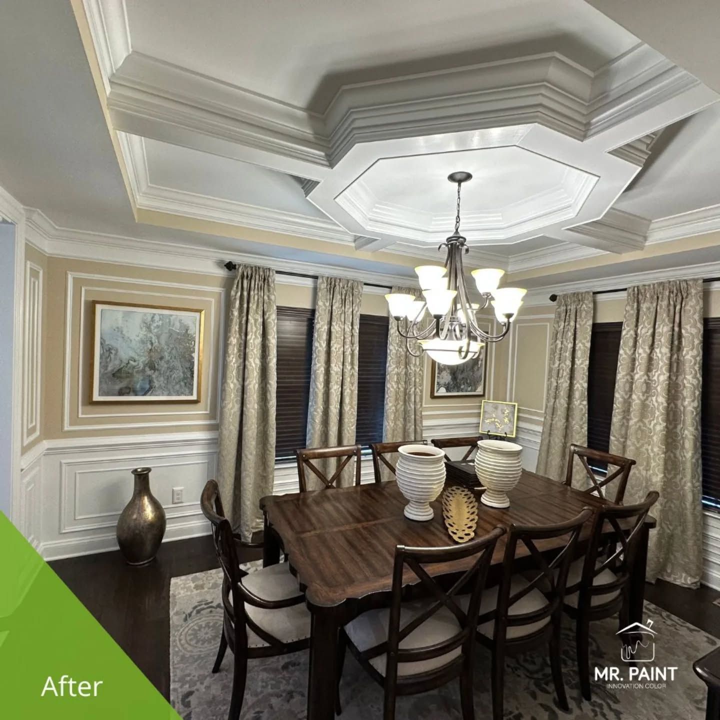 Dining room after renovation: dark wood table, chandelier, ornate ceiling, light walls, and curtains.