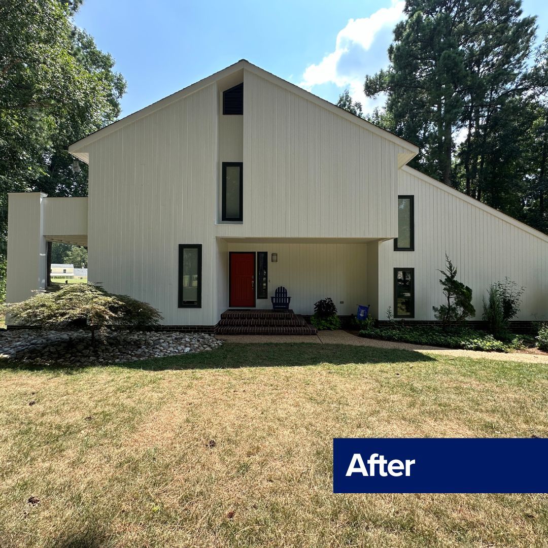 White house with red door and black window frames. 