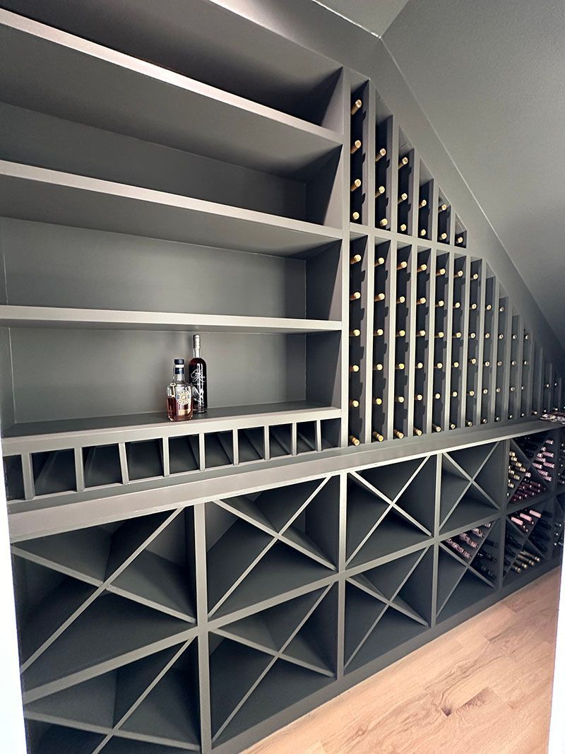Gray custom wine cellar with angled bottle storage and shelves.