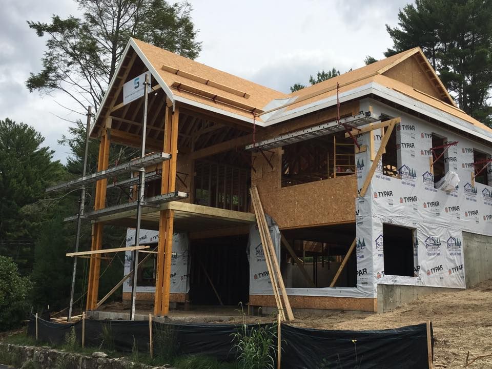 Interior of a dimly lit restaurant with tables set for dinner. Modern decor with hanging lights, dark tables, and gray chairs.