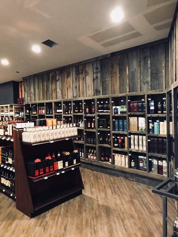 A restaurant interior with red booths and dark wood tables, adorned with overhead lights and artwork on the walls.