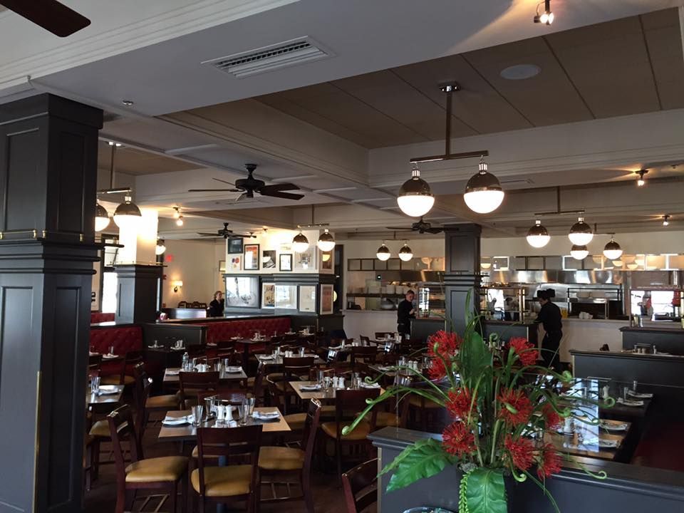 Inside a brightly lit liquor store with wooden shelves and flooring.  Beer and other beverages are displayed on shelves.