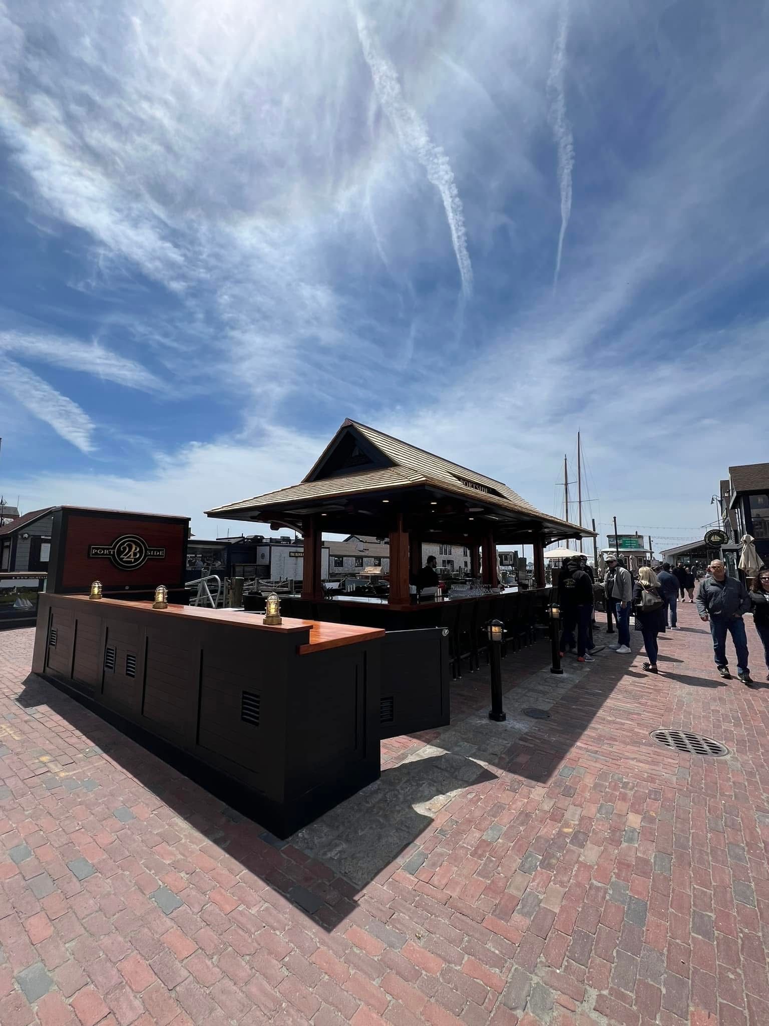 Outdoor bar with wooden structure and tile roof on brick street