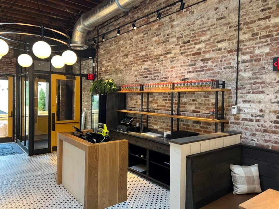 Interior of a restaurant with exposed brick walls, a counter, and seating