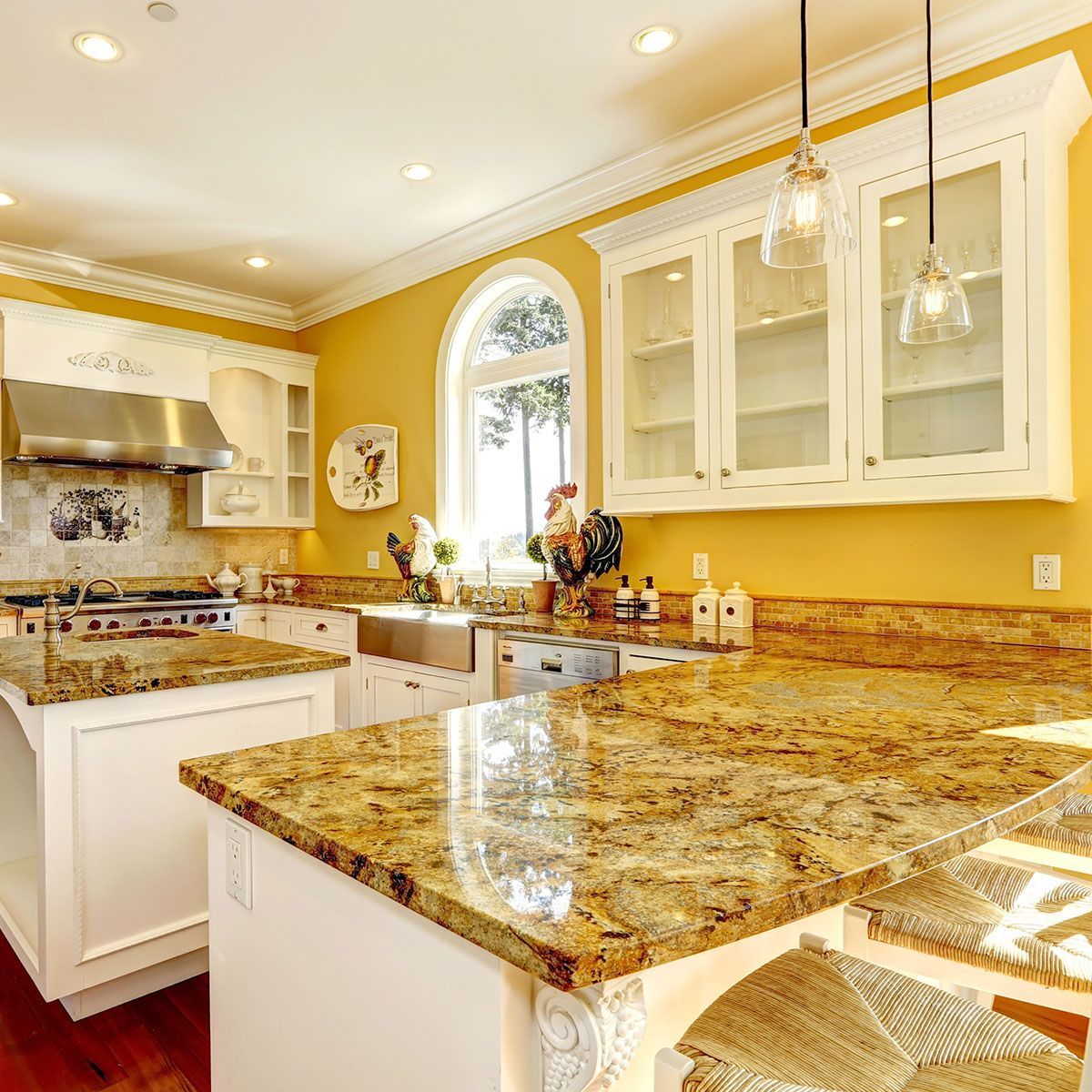 A kitchen with granite countertops and yellow walls