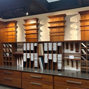 Wooden cabinetry display in a showroom, showcasing trim styles and material samples.