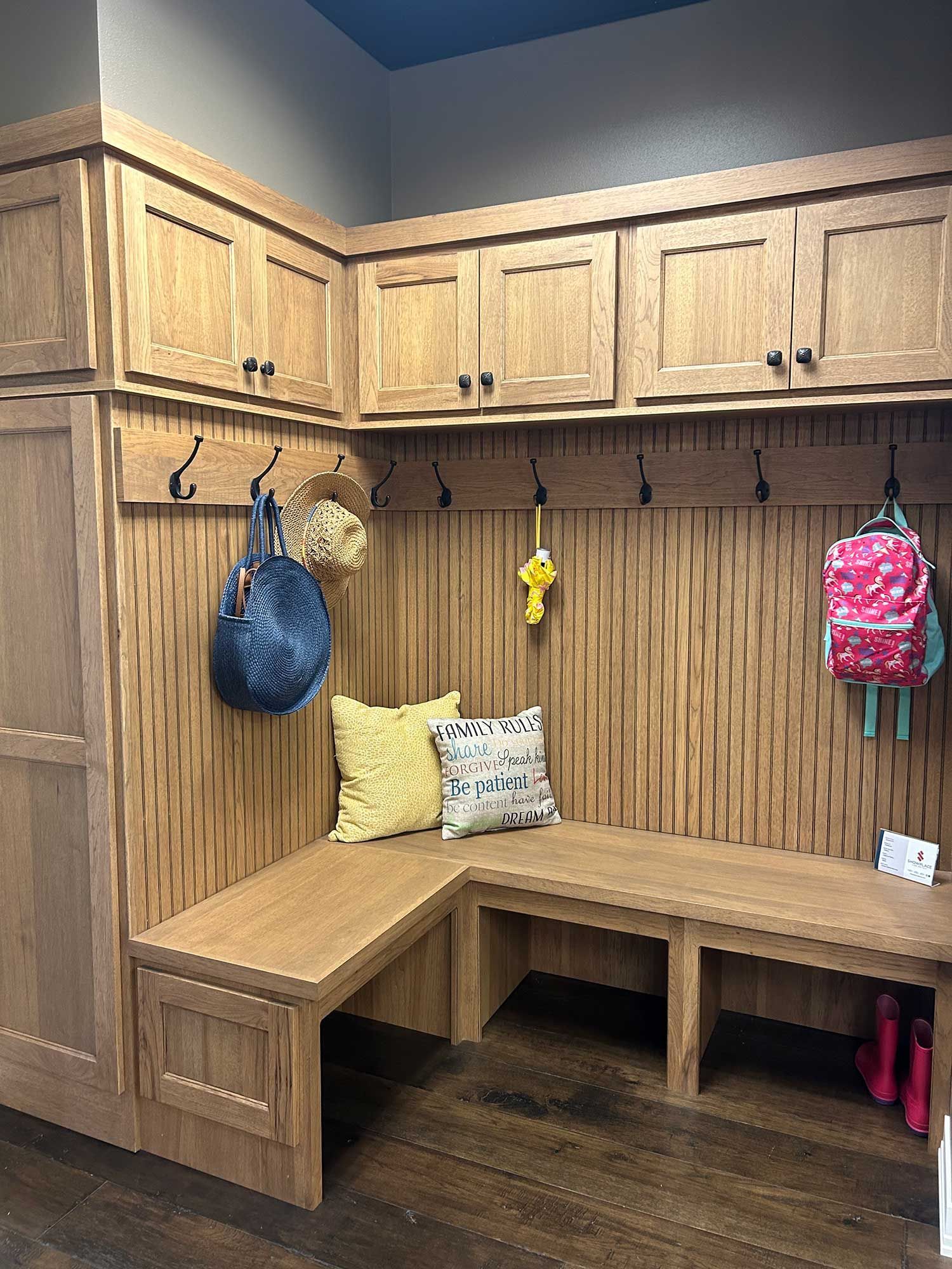 A wooden locker room with a bench and hooks on the wall.