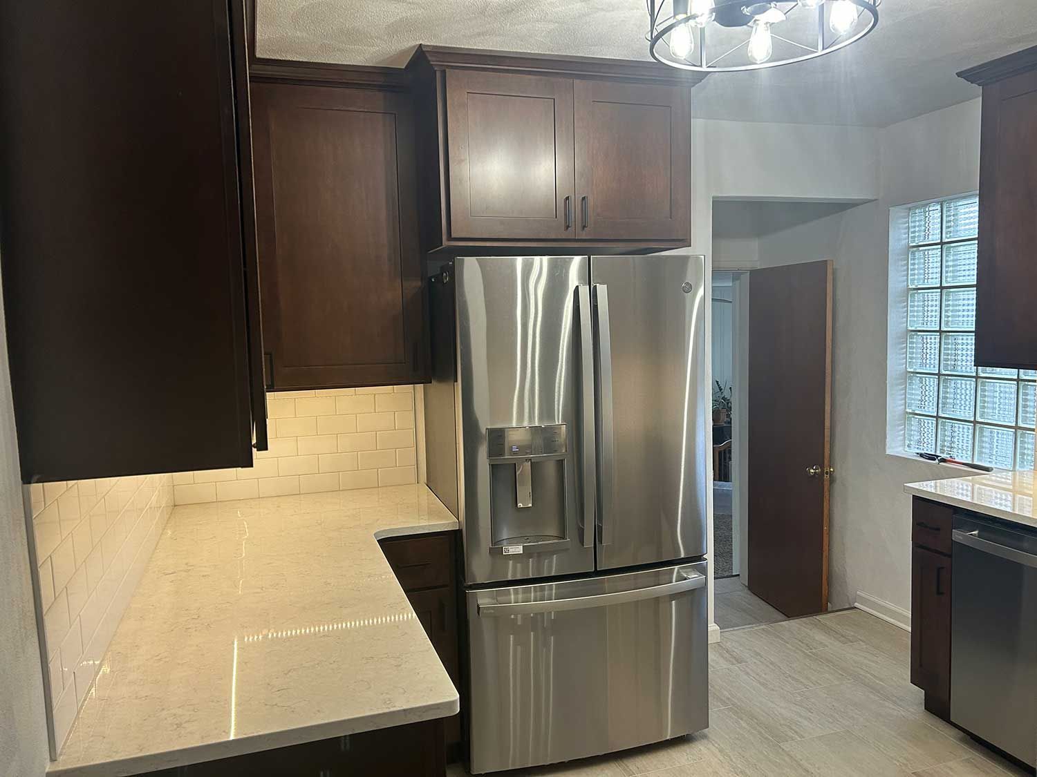A kitchen with stainless steel appliances and wooden cabinets.