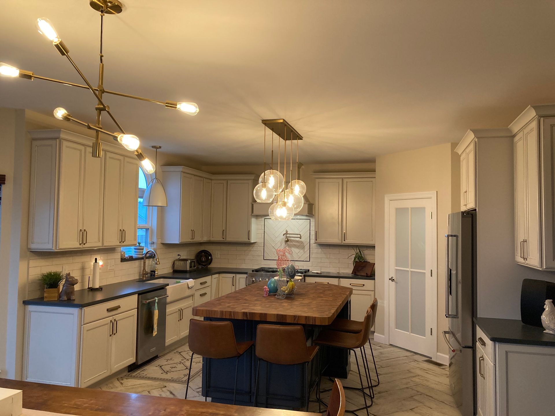 A kitchen with white cabinets and a large island in the middle.