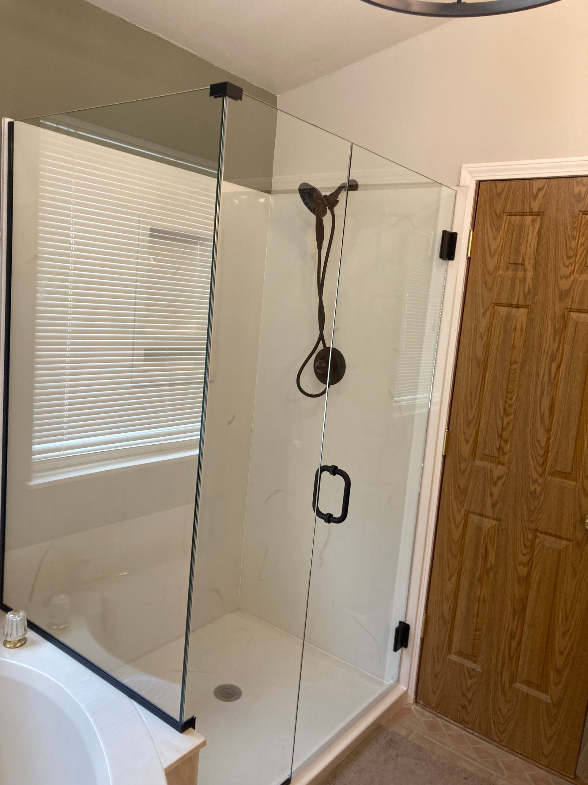A bathroom with a walk in shower and a wooden door.