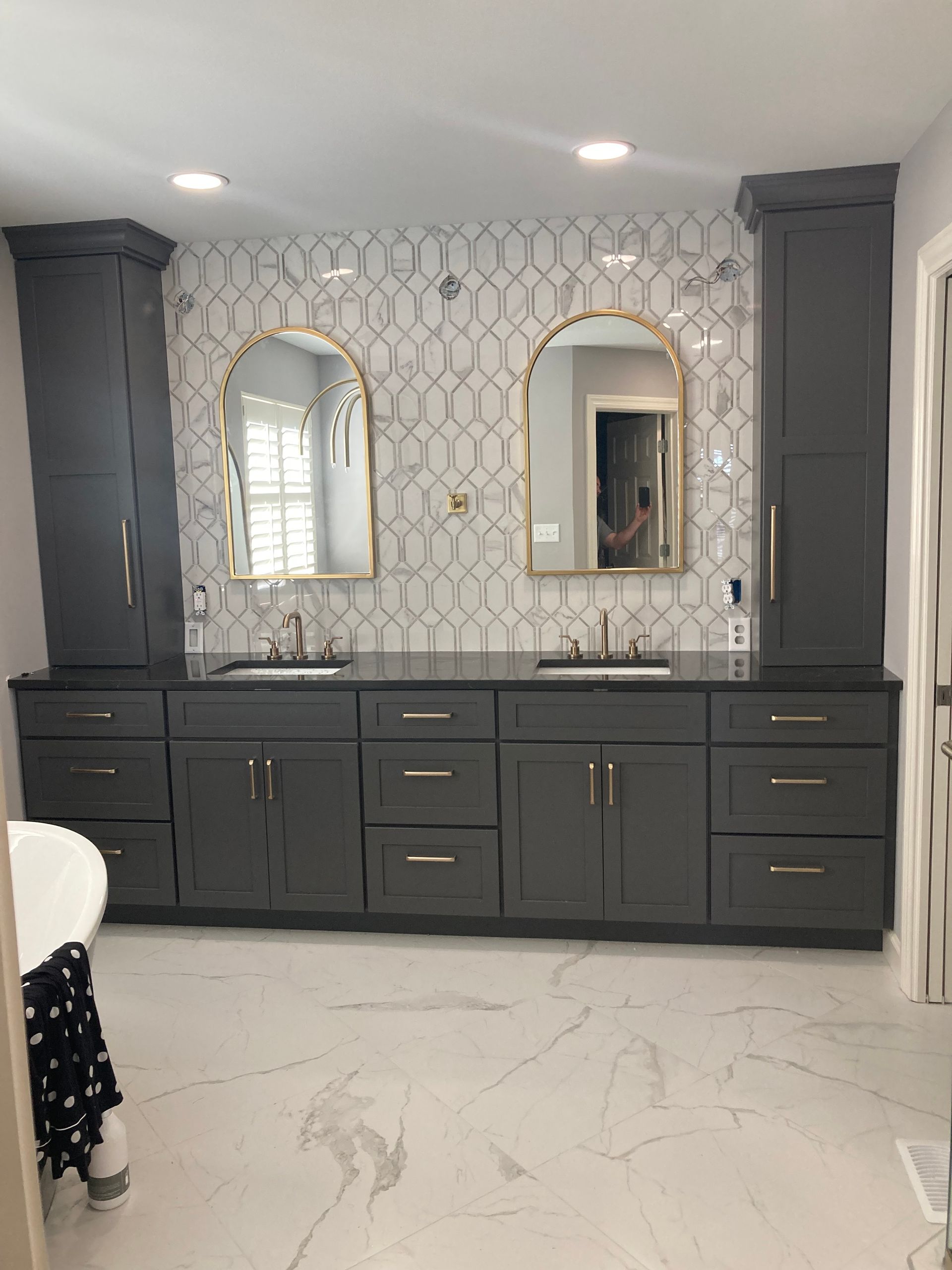 A bathroom with two sinks , two mirrors , and a bathtub.