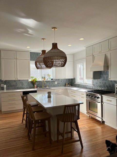 A kitchen with white cabinets and a large island