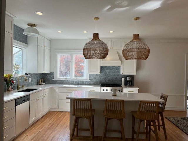 A kitchen with white cabinets and wooden floors