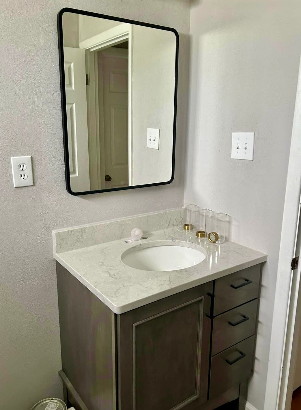 A bathroom with a sink and a mirror on the wall.