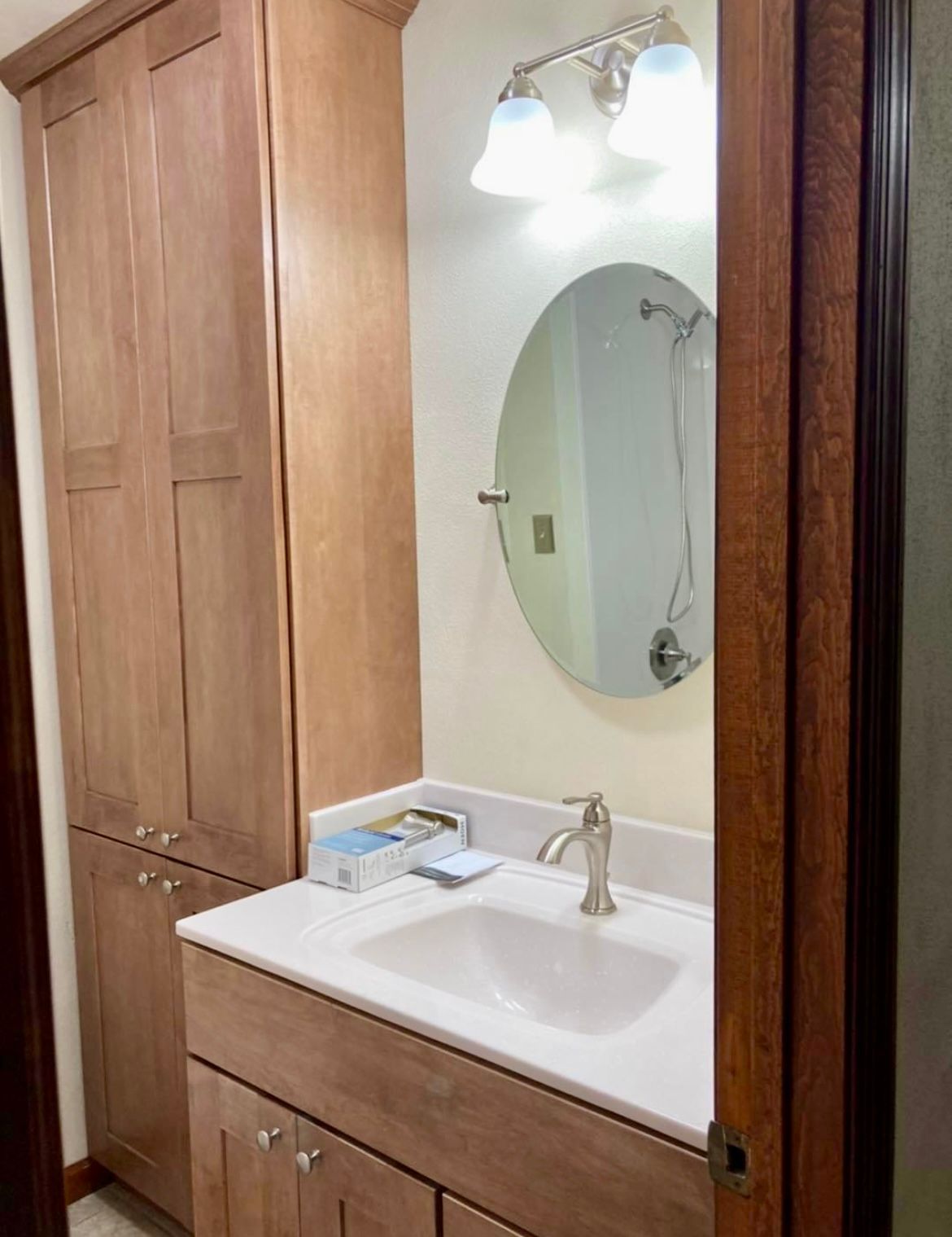 A bathroom with a sink , mirror and cabinets.