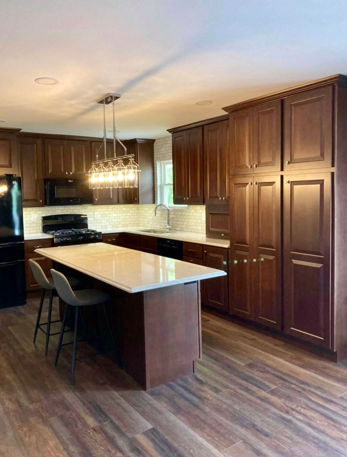 A kitchen with wooden cabinets and a large island.