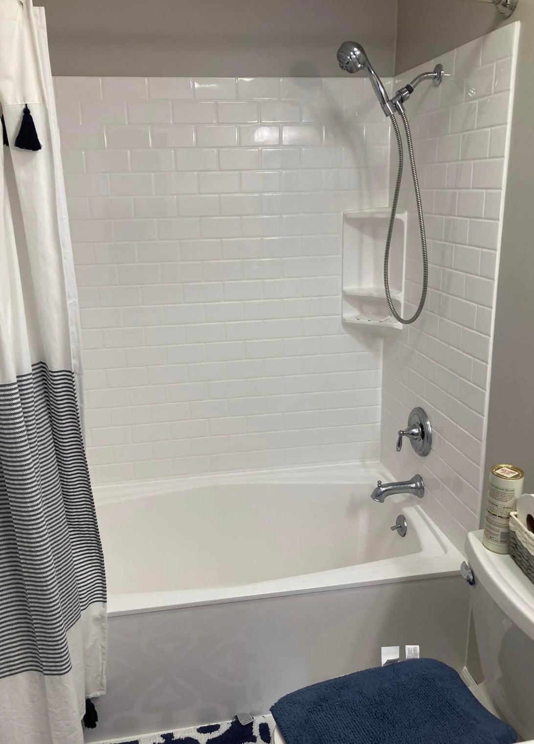 A bathroom with a bathtub , shower and toilet.