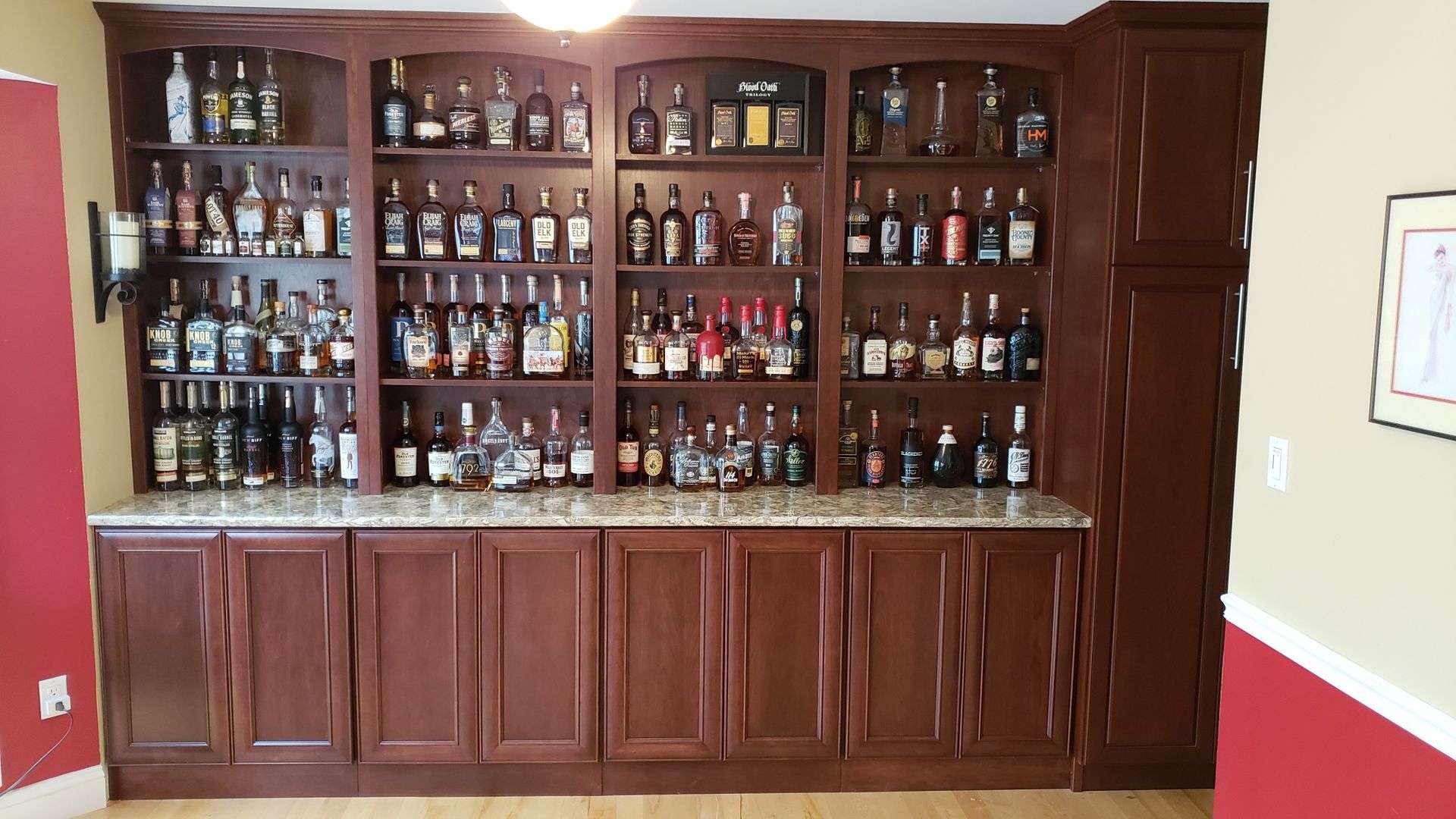 There are many bottles of alcohol on the shelves in this room.
